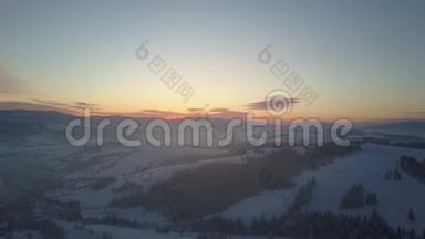 日出时空中北欧冬季景观飞越雪山森林。 冬季无人驾驶飞机飞越山区